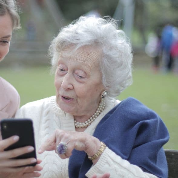 An older woman using ABAStroke app An older woman with white hair using an app on a smartphone