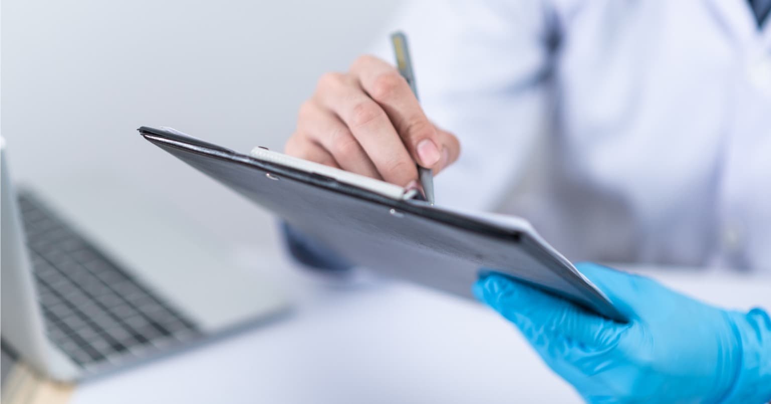 Digital health records on a tablet A doctor’s hand in latex glove holding a tablet with digital health records